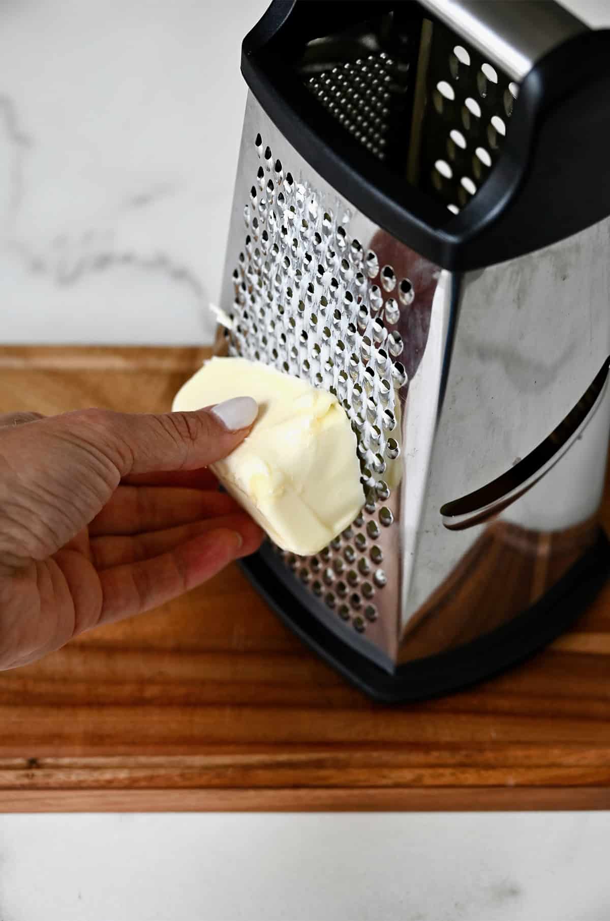 Grating cold butter on a box grater to bring it to room temperature quickly.