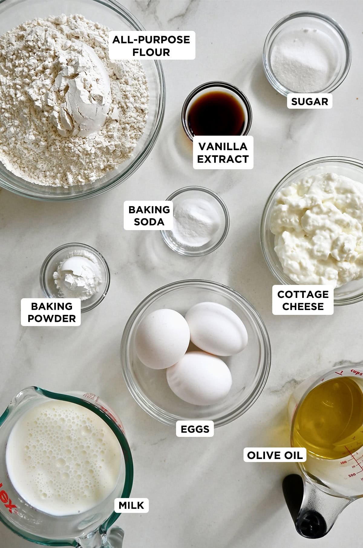 Various sizes of glass bowls containing the ingredients to make protein waffles with cottage cheese.