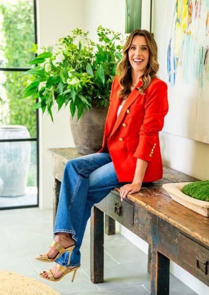 Kelly Senyei sitting on a console in an entryway