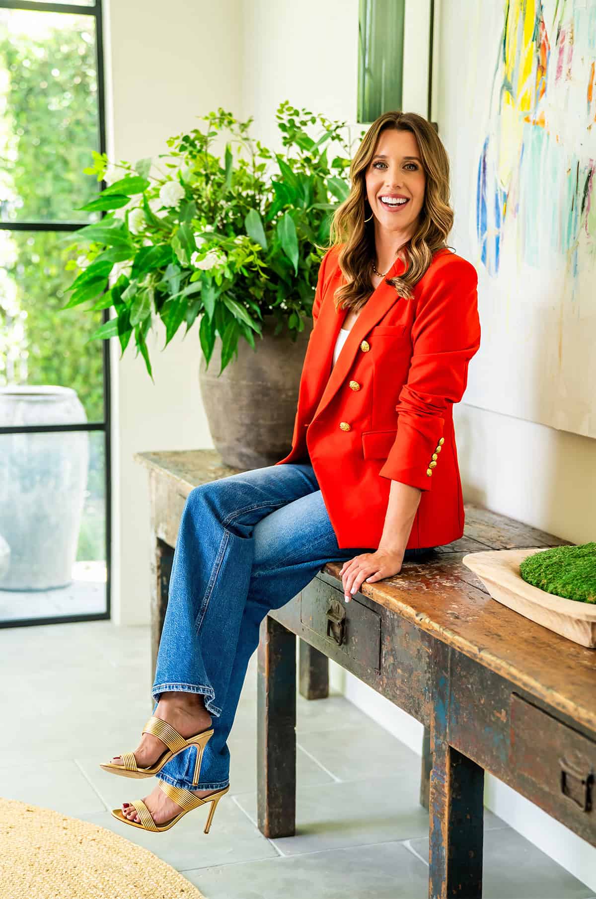 Kelly Senyei sitting on a console in an entryway