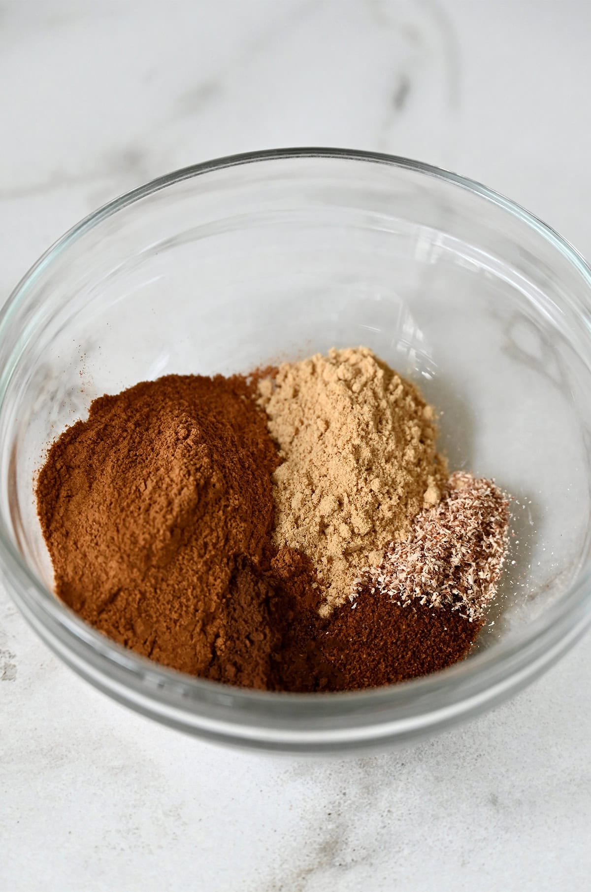 A small bowl containing ground allspice, cinnamon, ginger, nutmeg and cloves.