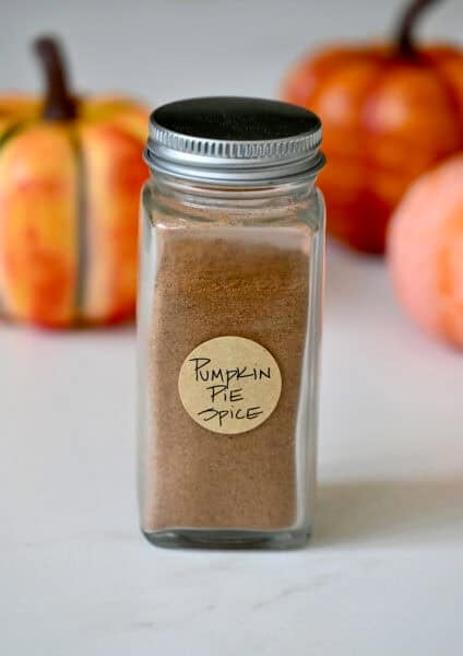 Homemade pumpkin pie spice in a spice jar with a handwritten label.