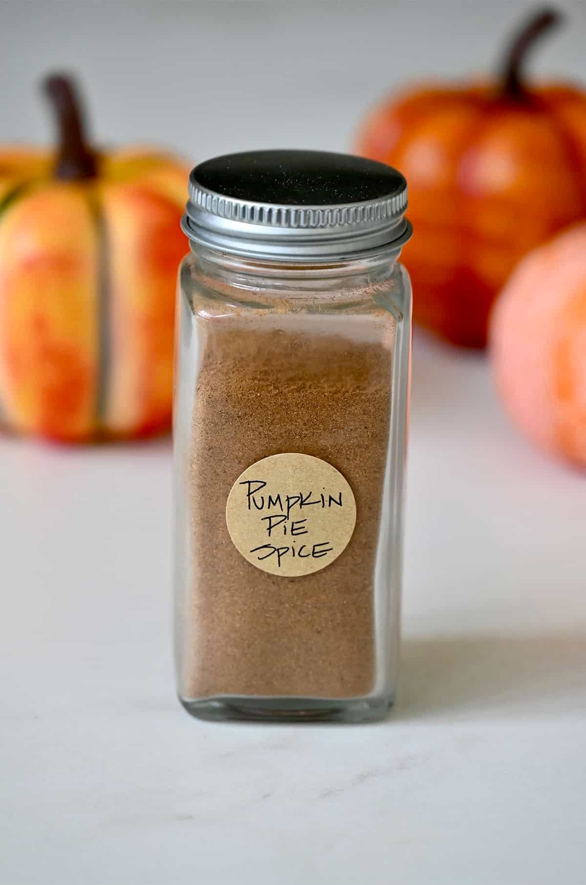 Homemade pumpkin pie spice in a spice jar with a handwritten label.