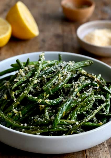 Roasted green beans with grated Parmesan in a serving bowl.