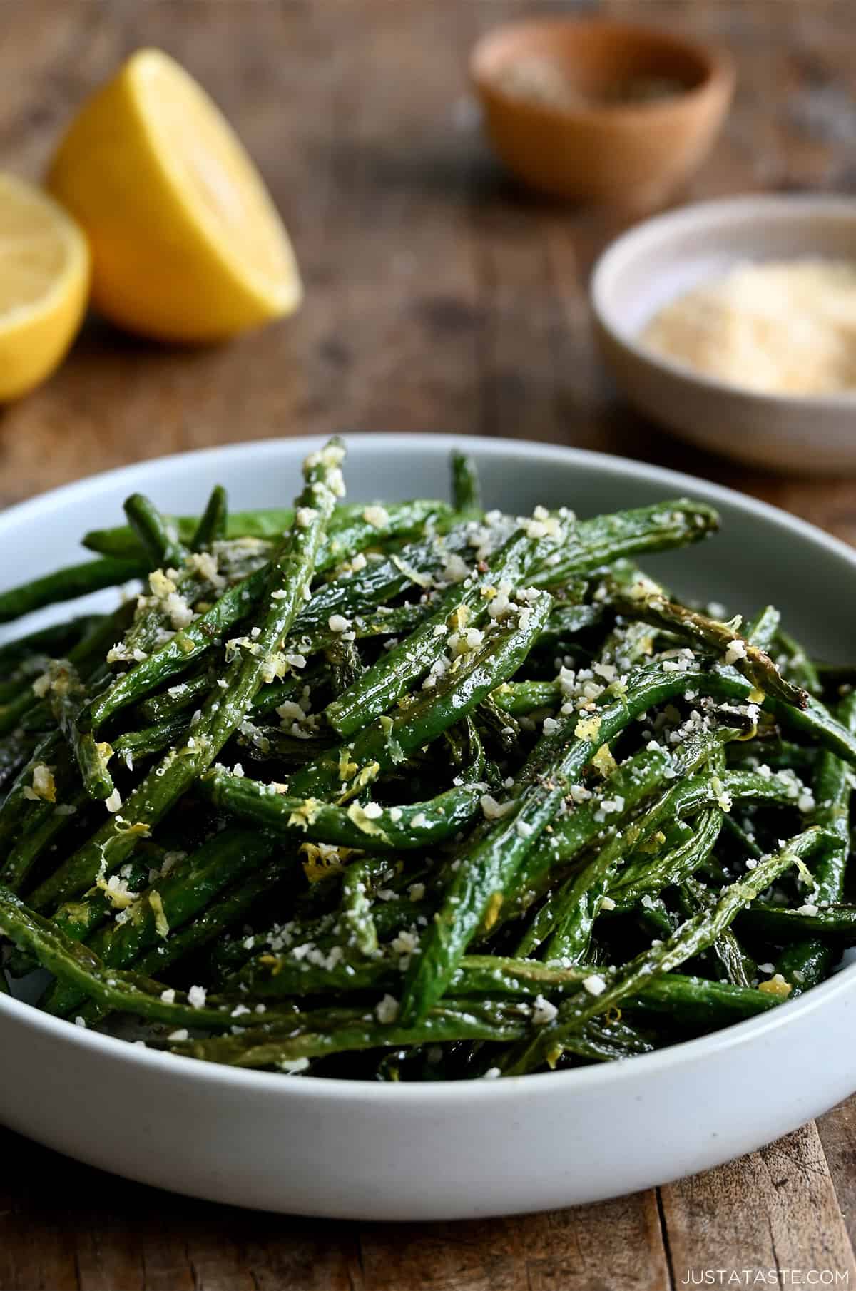 Roasted green beans with grated Parmesan in a serving bowl.