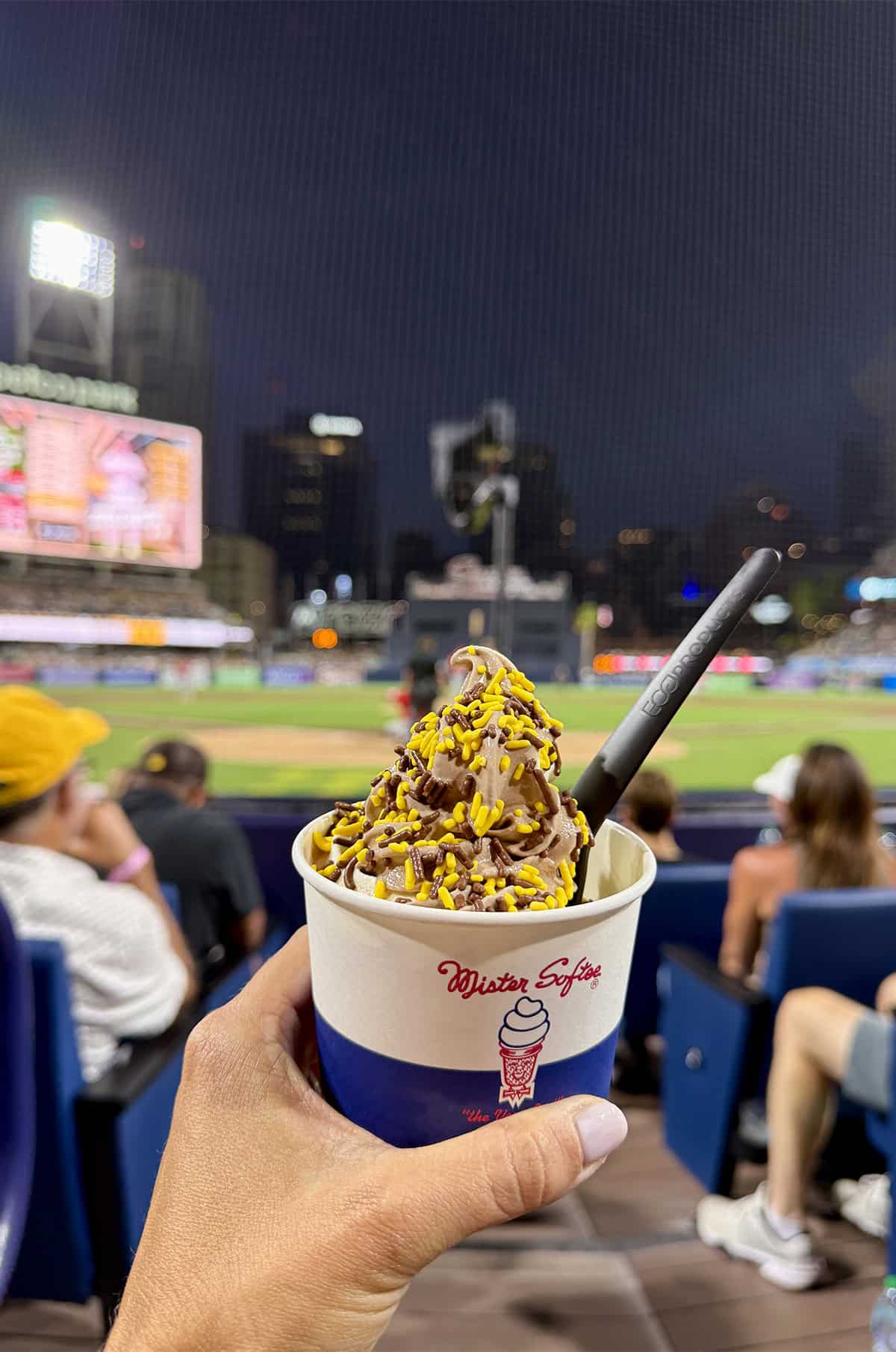 A Mister Softee cup filled with soft serve ice cream topped with sprinkles