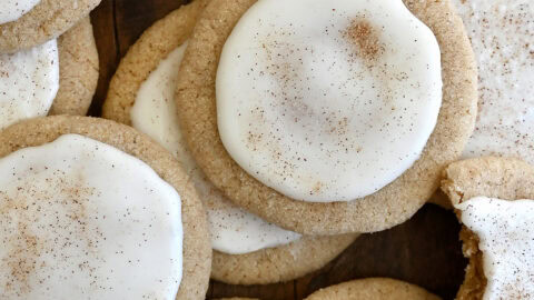 Taylor Swift chai cookies with eggnog icing piled atop each other with a bite taken out of one cookie.