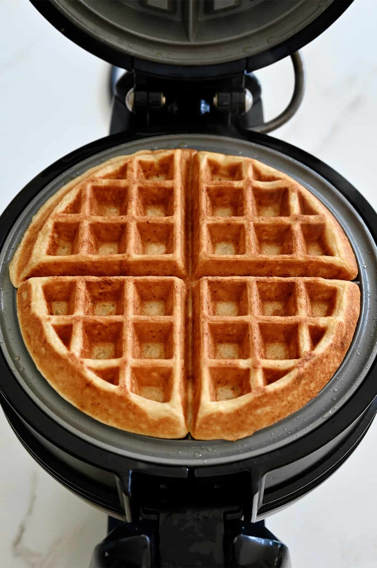 Golden brown, fluffy, crisp protein waffle in a Belgian waffle maker.