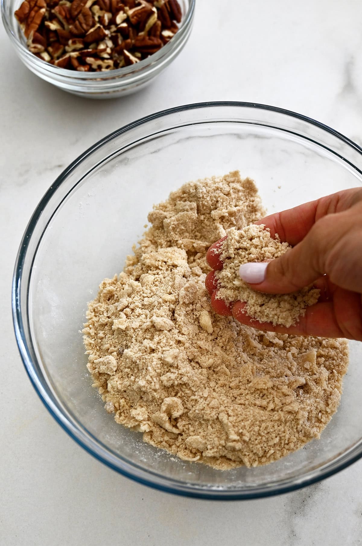 Butter pecan topping for sweet potato casserole in a glass bowl.