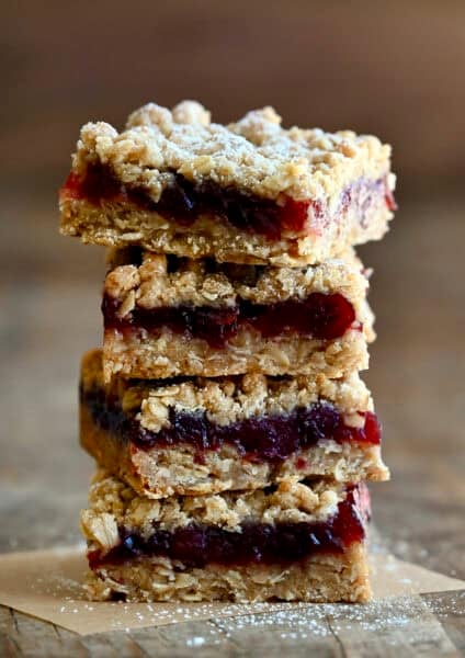 Four cranberry crumble bars stacked atop each other.