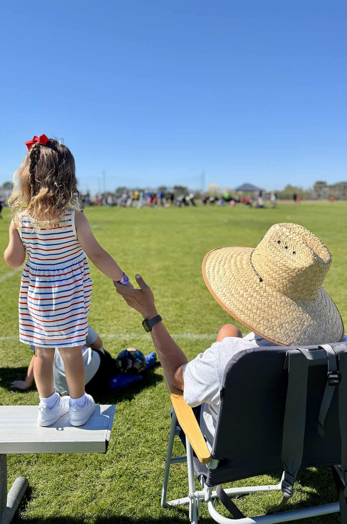 Granddaughter and grandpa together on a soccer field