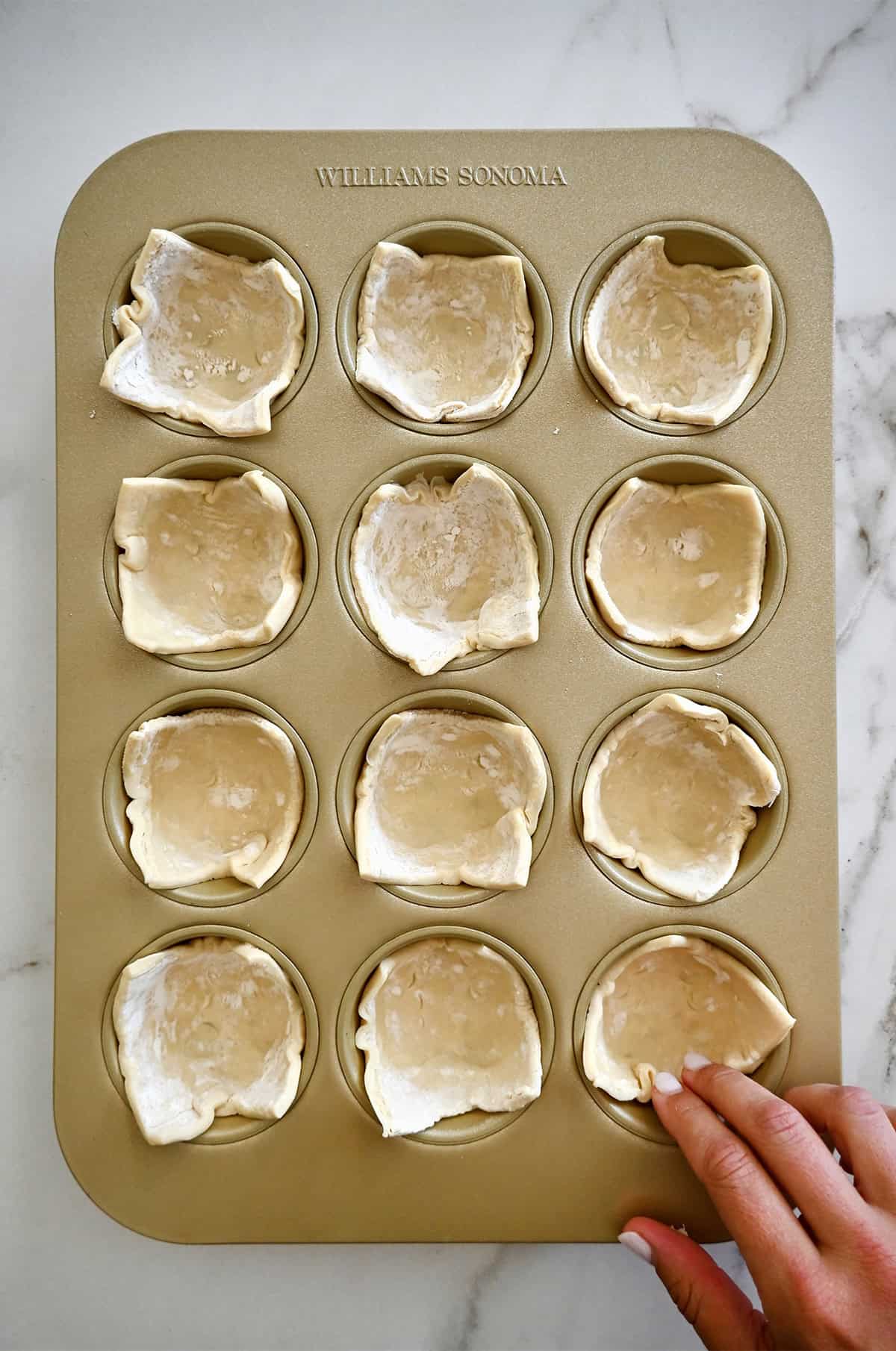 Sluoksniuotos tešlos kvadratas kiekviename standartinės 12 puodelių bandelių keptuvės puodelyje.
