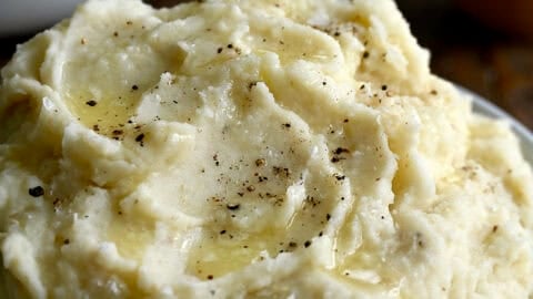 Roasted garlic mashed potatoes in a white serving bowl.