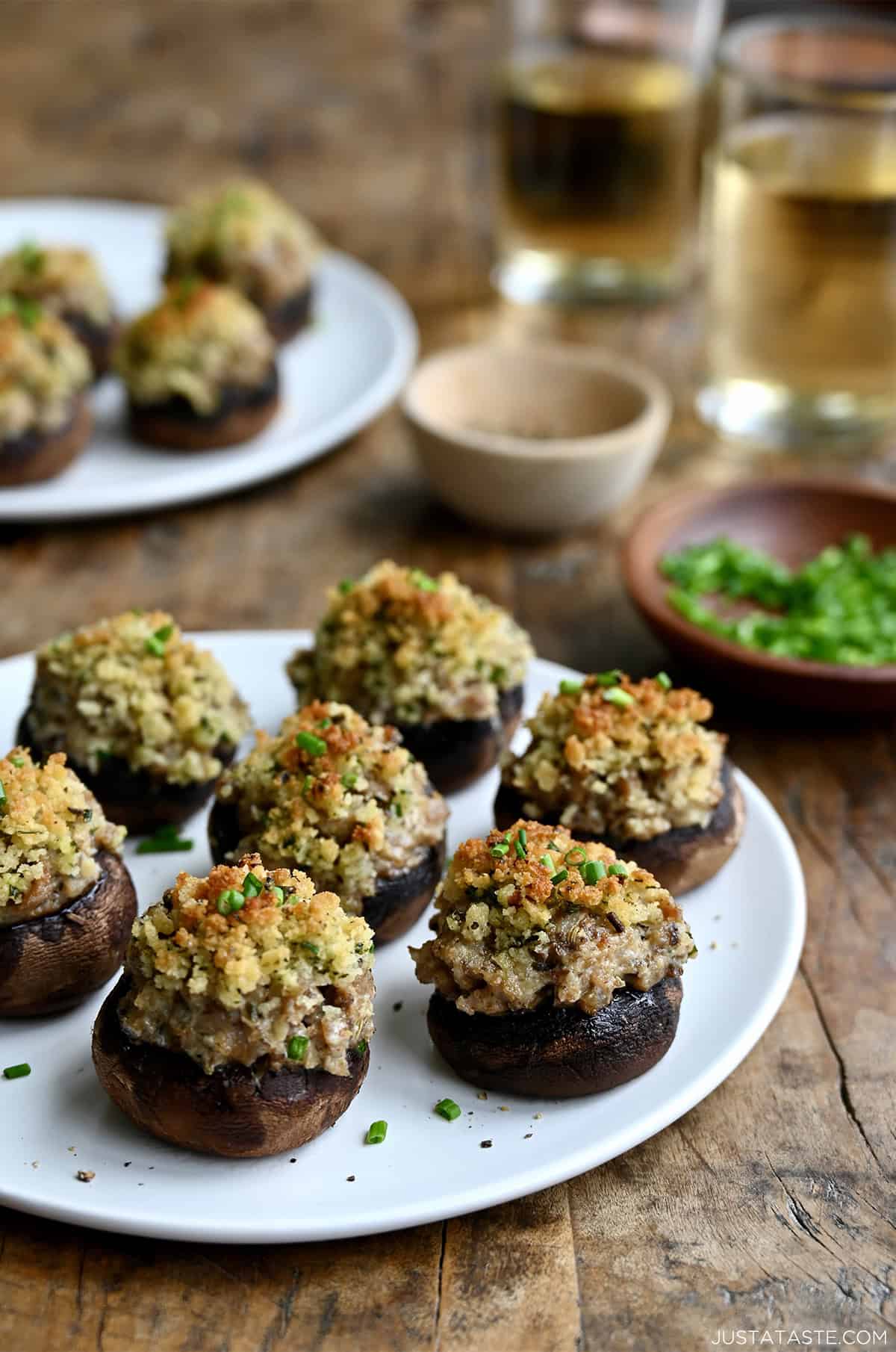 Sausage stuffed mushrooms on a white appetizer plate.