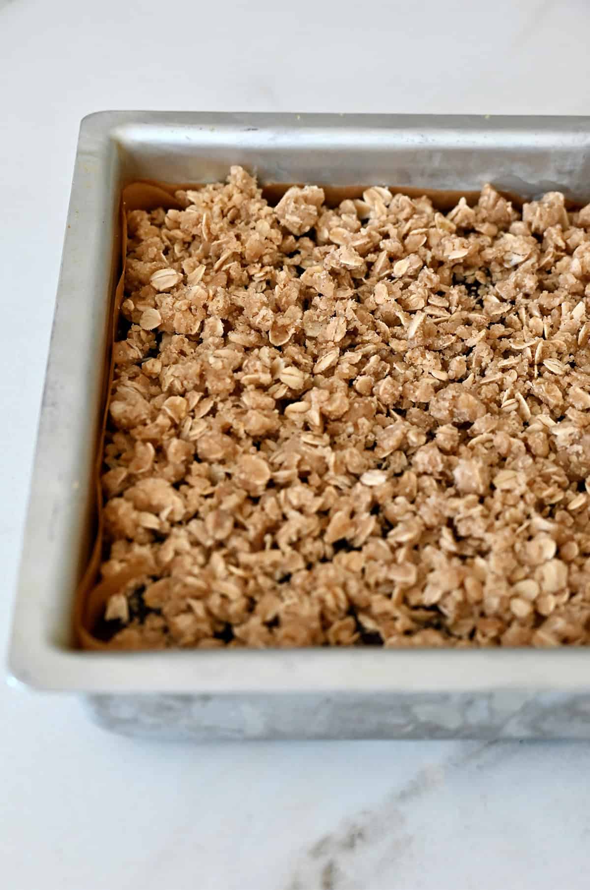 Crumble topping atop cranberry bars before being baked to golden brown perfection.
