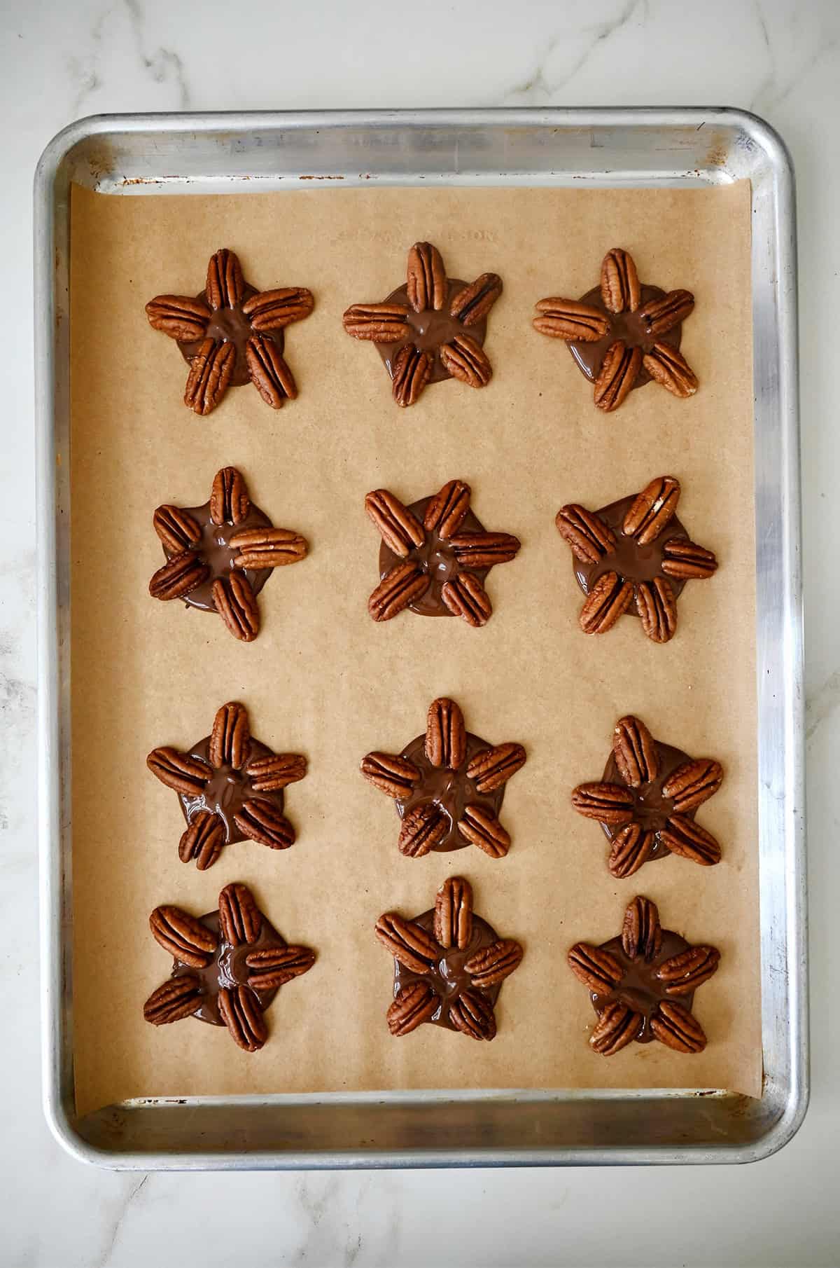Pecan halves arranged on top of melted chocolate to form "turtles."