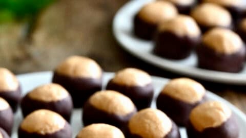 Buckeyes, also known as peanut butter balls coated with chocolate, on a serving plate.