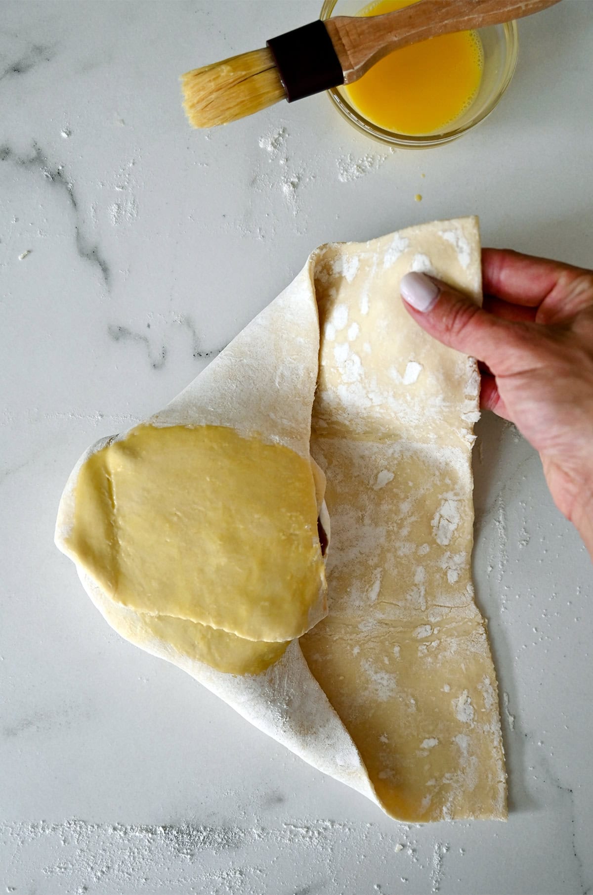 Wrapping Brie cheese in puff pastry.