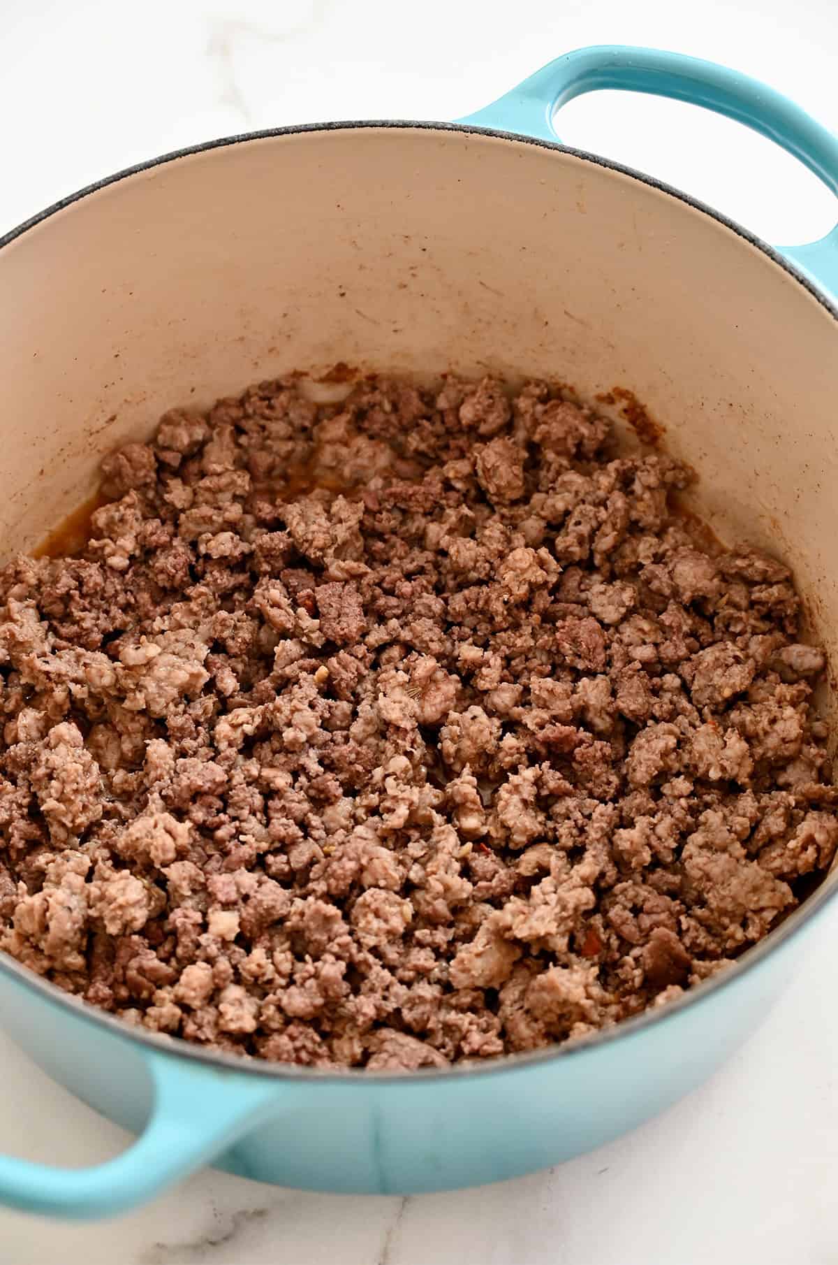 Browned ground beef and Italian sausage in a large pot.