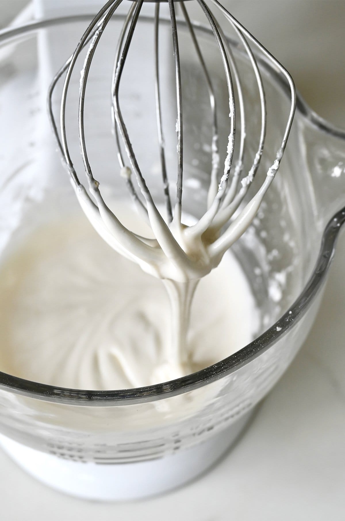 Royal icing made with meringue powder in a stand mixer bowl.
