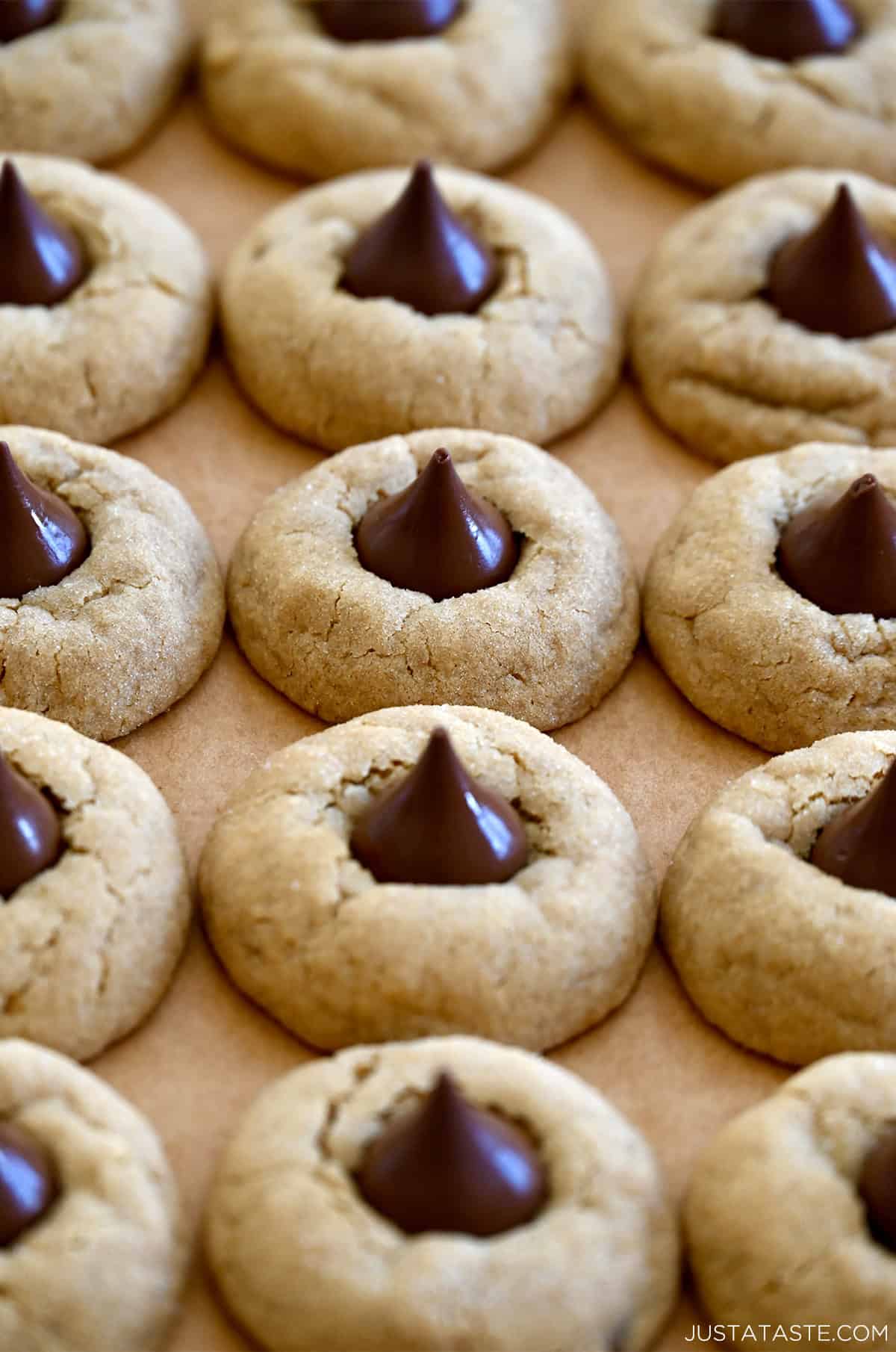 Soft and chewy peanut butter blossoms on brown parchment paper.