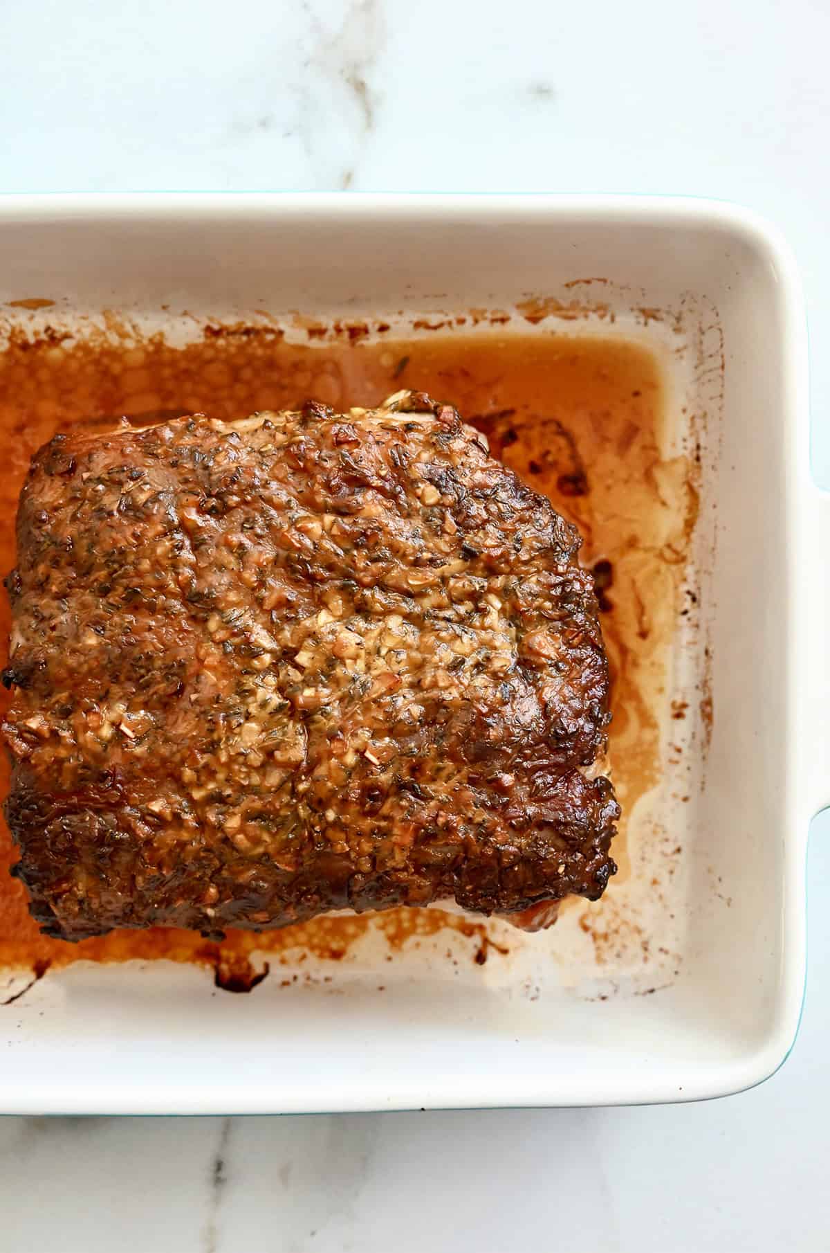 Roasted pork in a white baking dish.