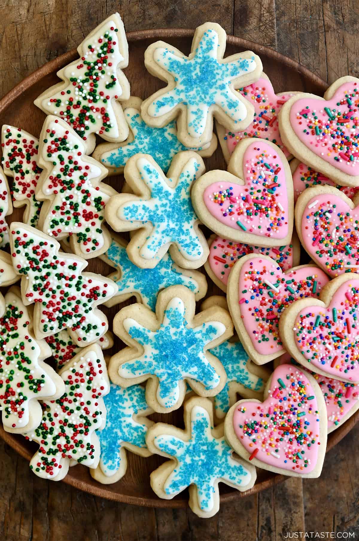 Sugar cookies with royal icing and sprinkles on a plate.