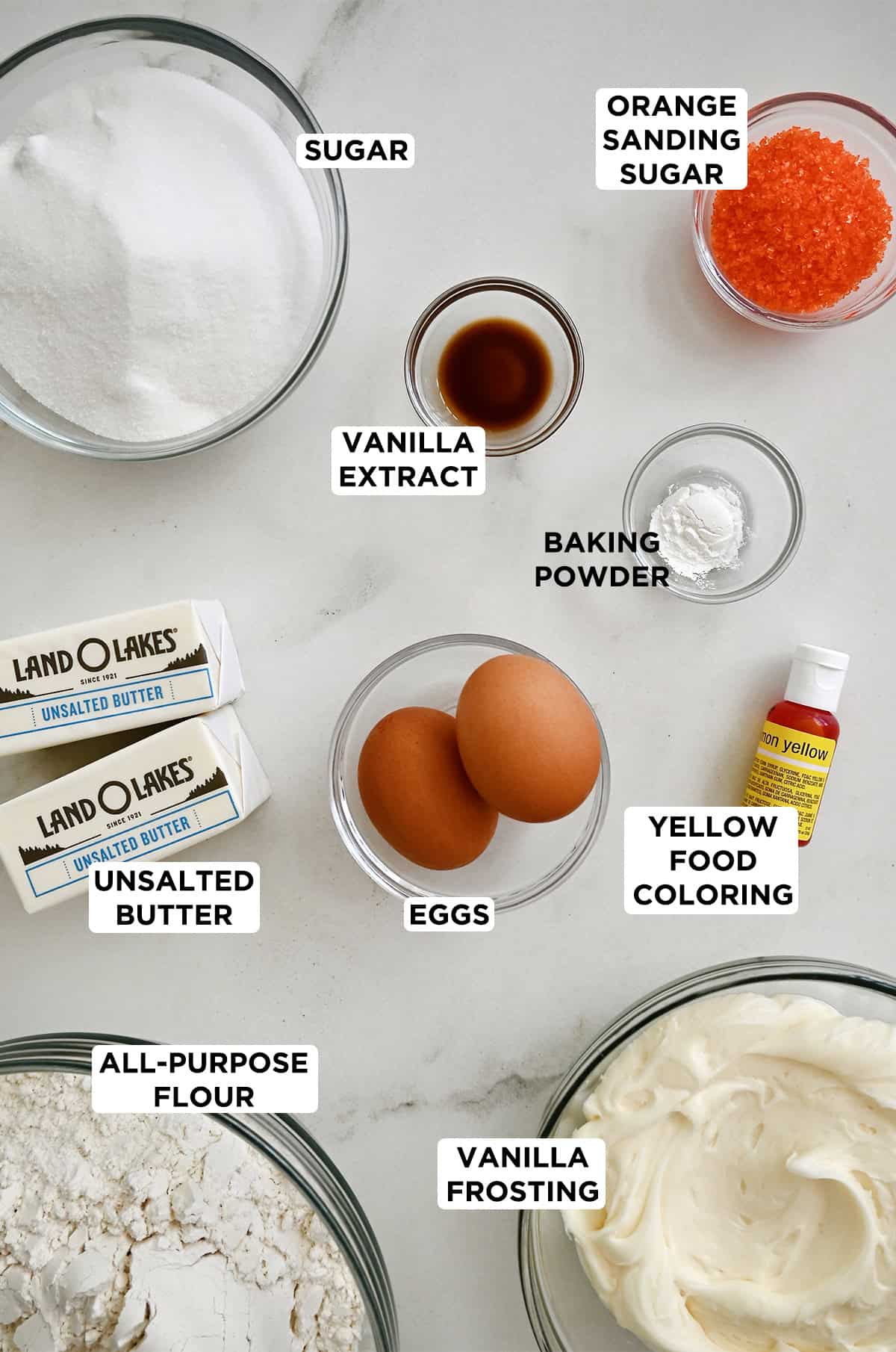 Ingredients to make sugar cookie cups with yellow-tinted vanilla frosting.