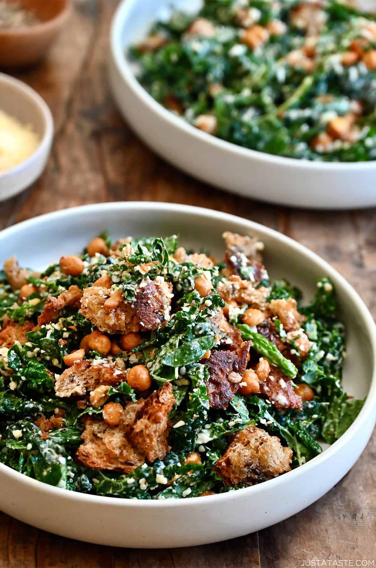 Homemade croutons atop a kale salad on a plate.