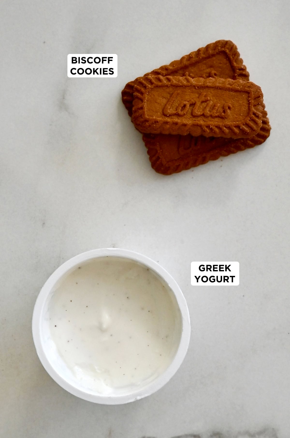 Biscoff cookies next to a single serving of yogurt to make the viral Japanese cheesecake.