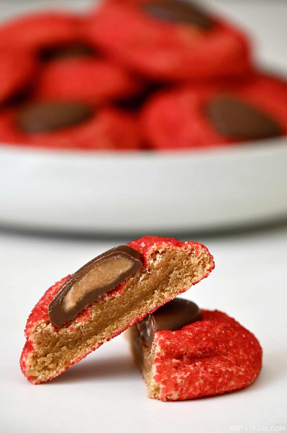 A peanut butter heart cookie cut in half, exposing the Reese's Peanut Butter Heart center and soft peanut butter cookie middle.