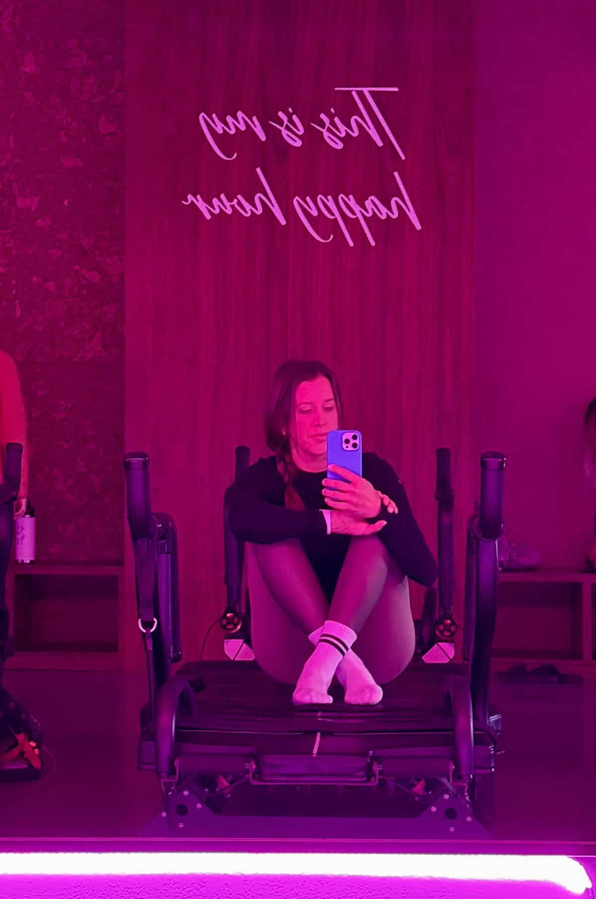 Kelly Senyei sitting on a lagree reformer for pilates