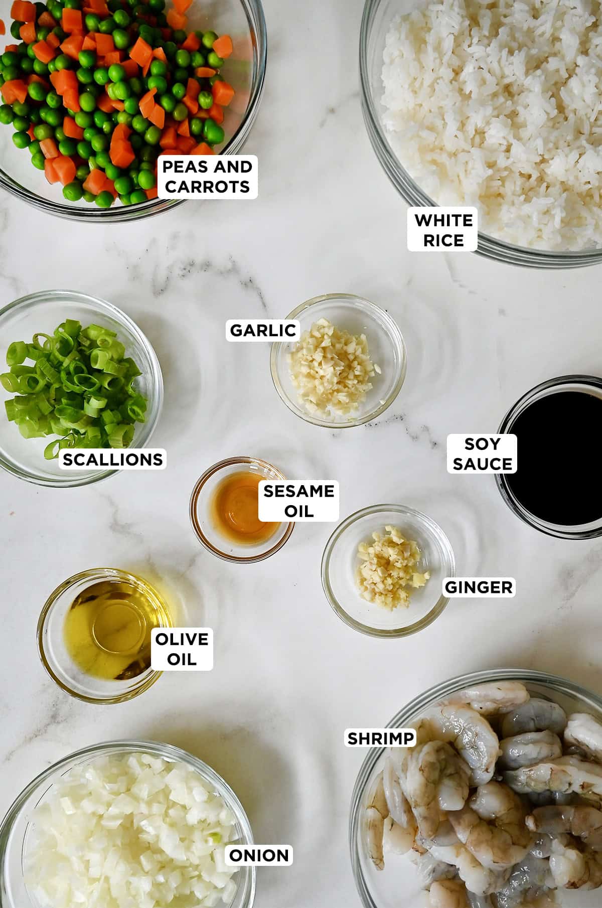 Shrimp fried rice ingredients in various sizes of glass bowls.