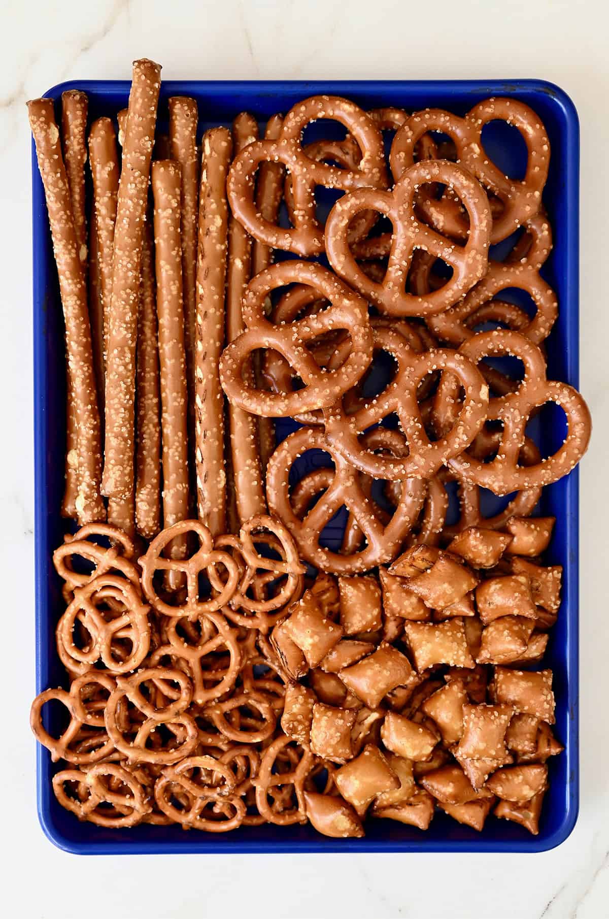 A tray full of various shapes and sizes of pretzels, including pretzel rods, mini pretzels, peanut butter-filled pretzels and thick pretzels.