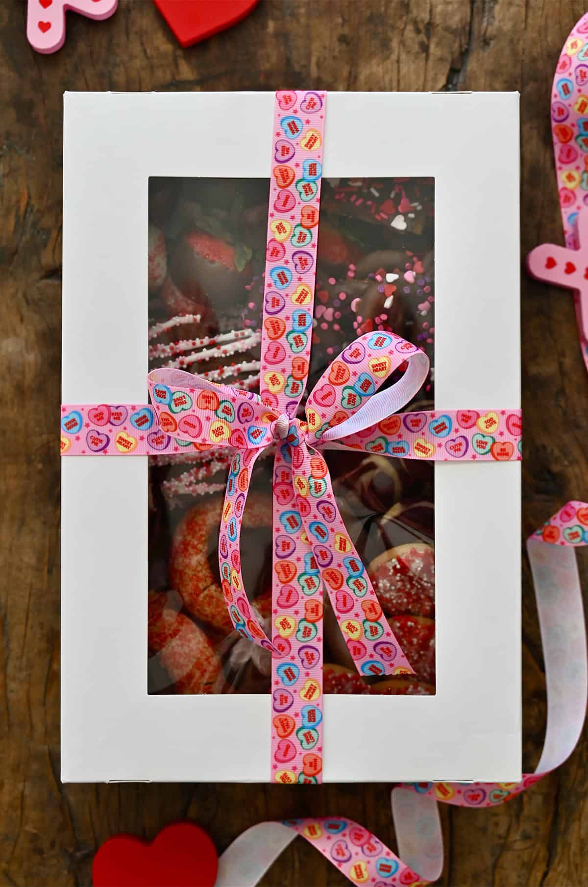 A Valentine's Day dessert box tied up with a conversation hearts ribbon.
