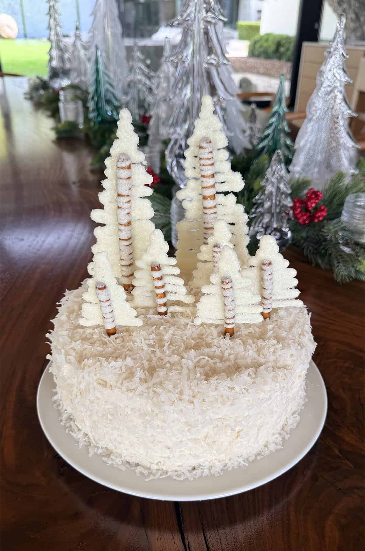 Edible white chocolate Christas trees on a coconut cake