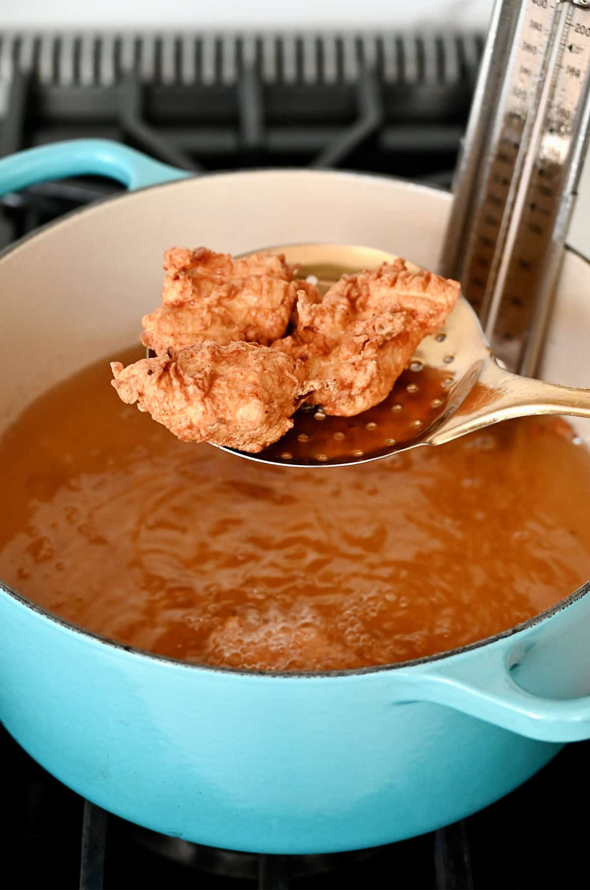 Frying battered pieces of chicken in hot oil.