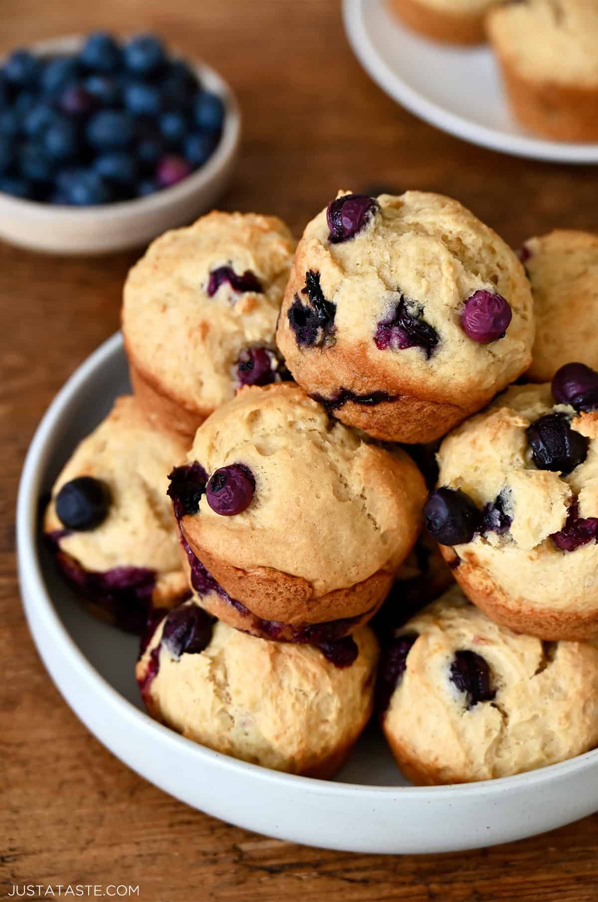 Cottage cheese muffins with juicy blueberries piled high on a plate.