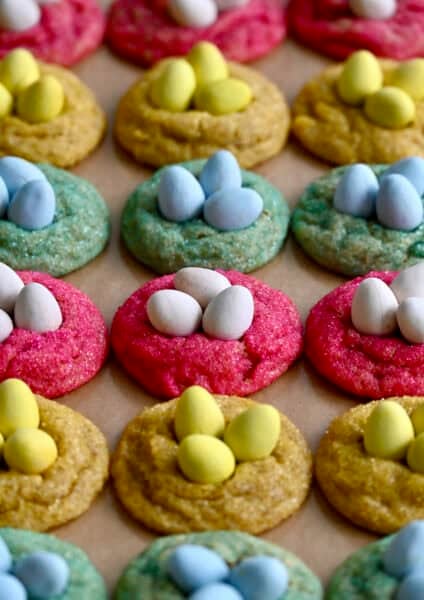 Cadbury mini egg cookies rolled in yellow, pink and blue sanding sugar with mini Cadbury eggs nestled in the center.