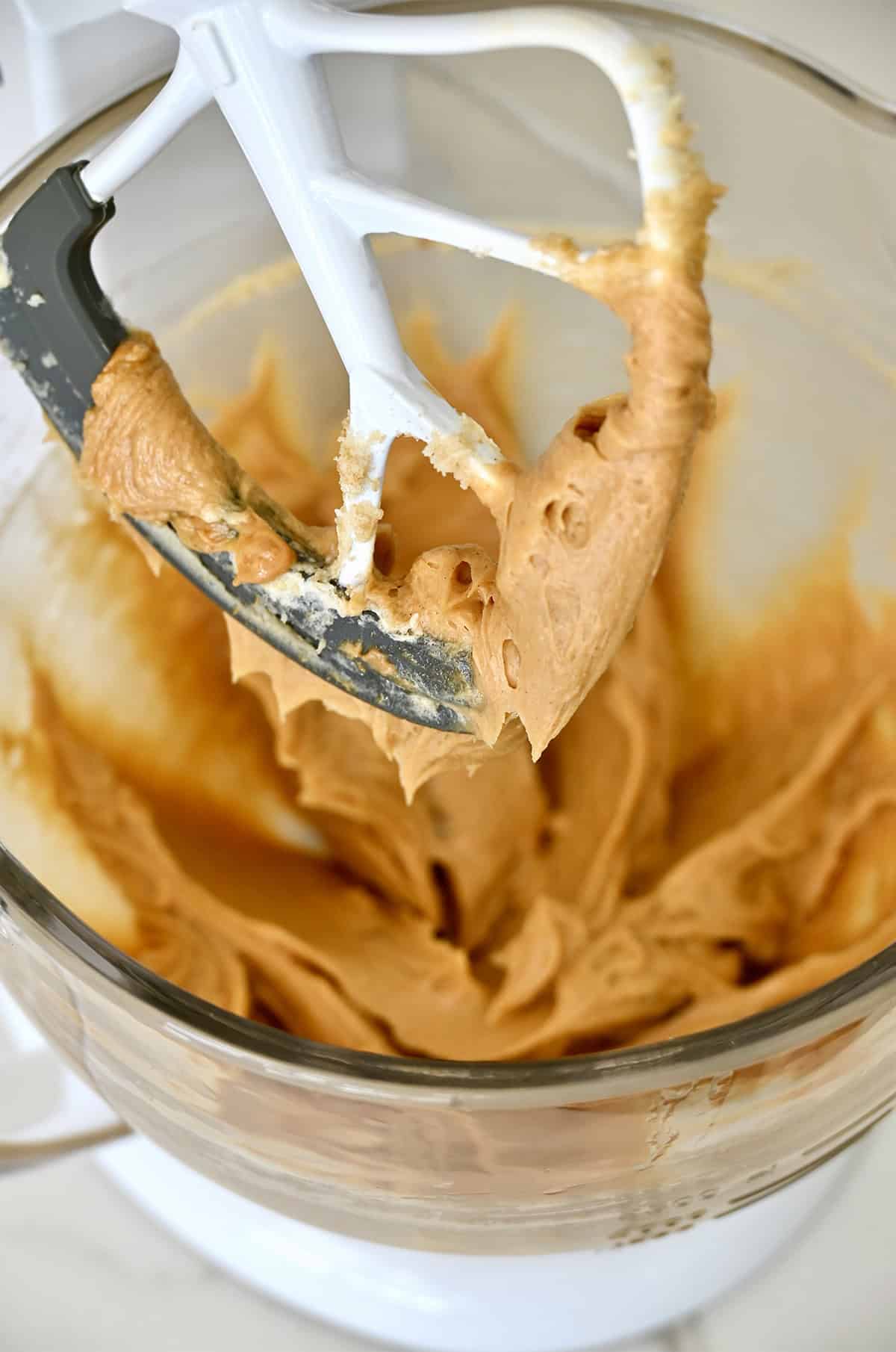 Peanut butter cookie dough in the bowl of a stand mixer.