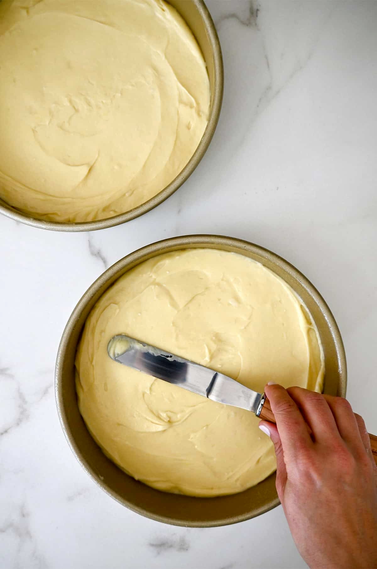 Two round cake pans with coconut cake batter.