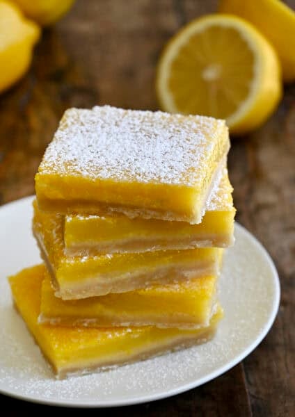 Lemon bars stacked five high and dusted with powdered sugar.