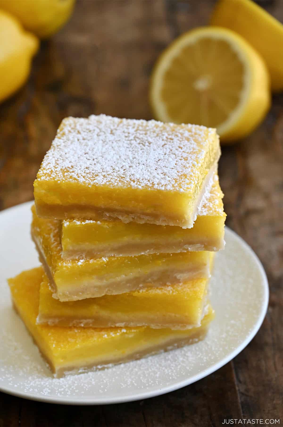 Lemon bars stacked five high and dusted with powdered sugar.