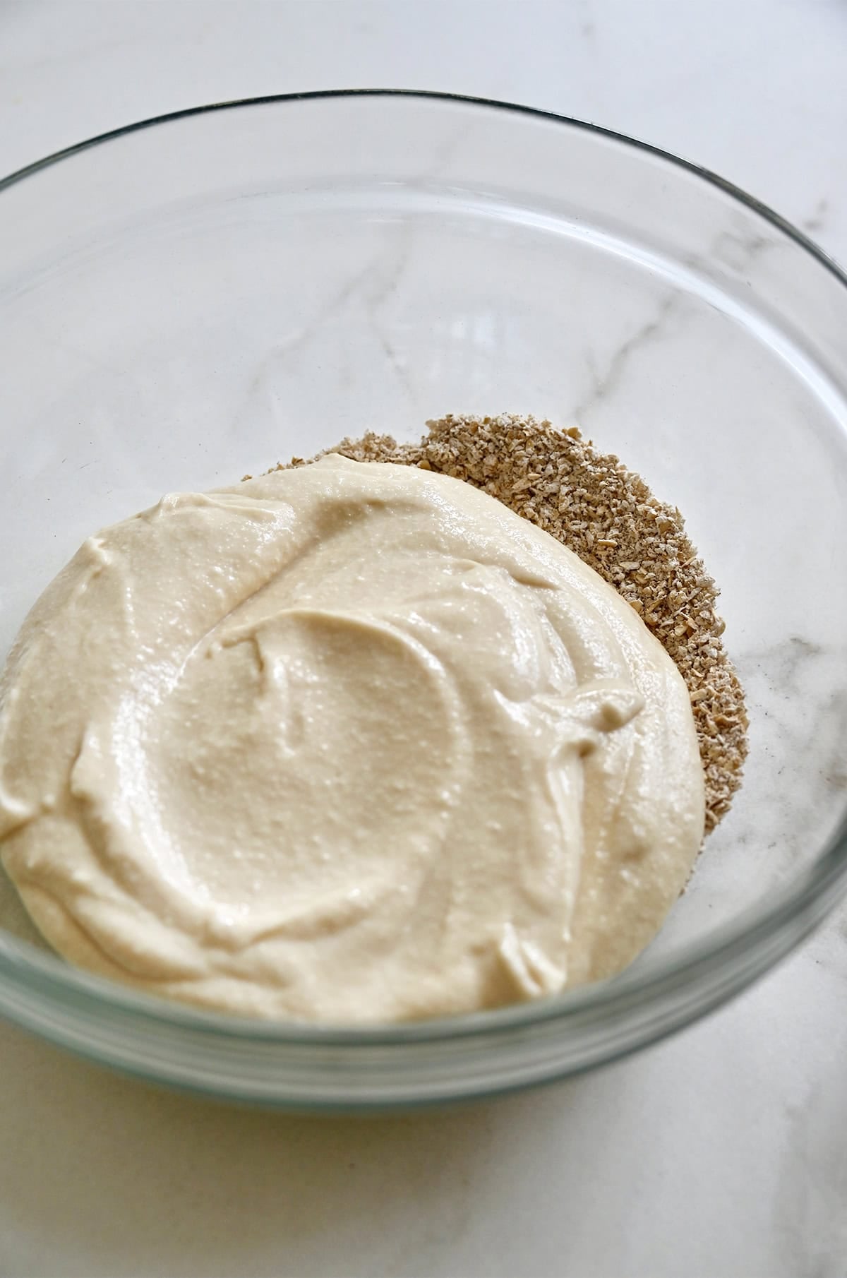 Mixing blended cottage cheese with oat flour and cinnamon to make high-protein cookie dough.
