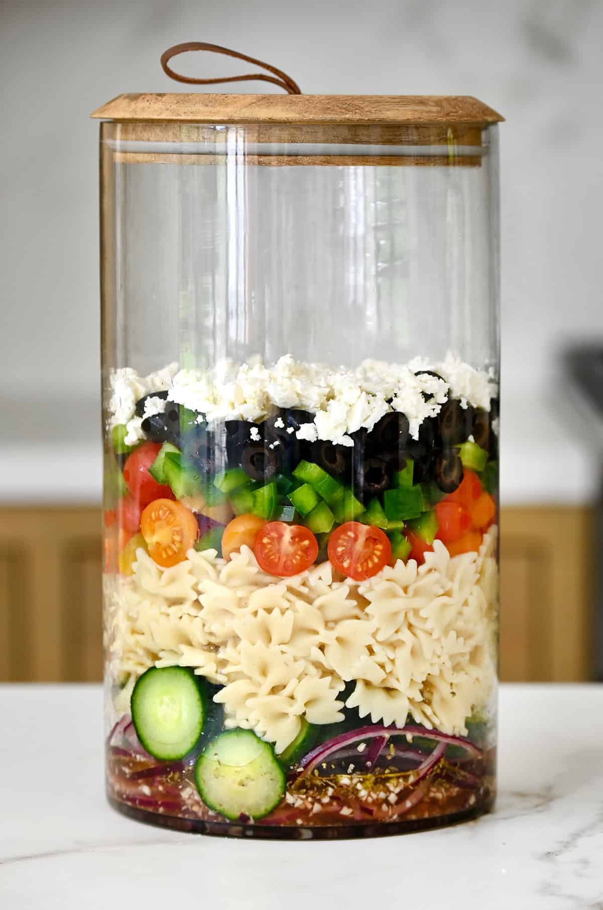 How to layer pasta salad into a tall container to keep it from getting soggy.
