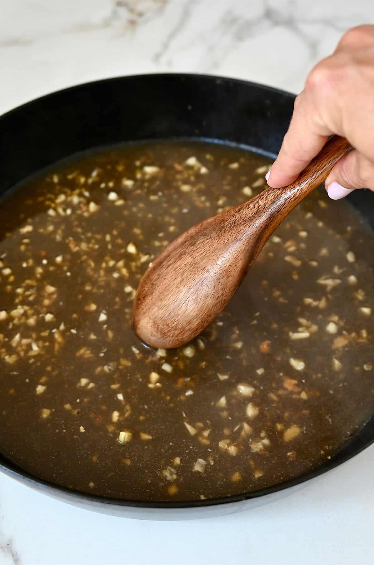 Chicken stock and sautéed garlic in a large skillet.