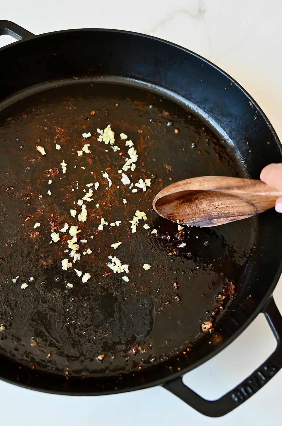Sautéing garlic in a large skillet.