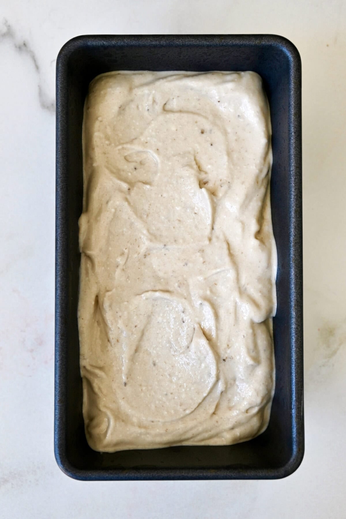 Creamy banana cottage cheese ice cream in a loaf pan, ready to stash in the freezer.