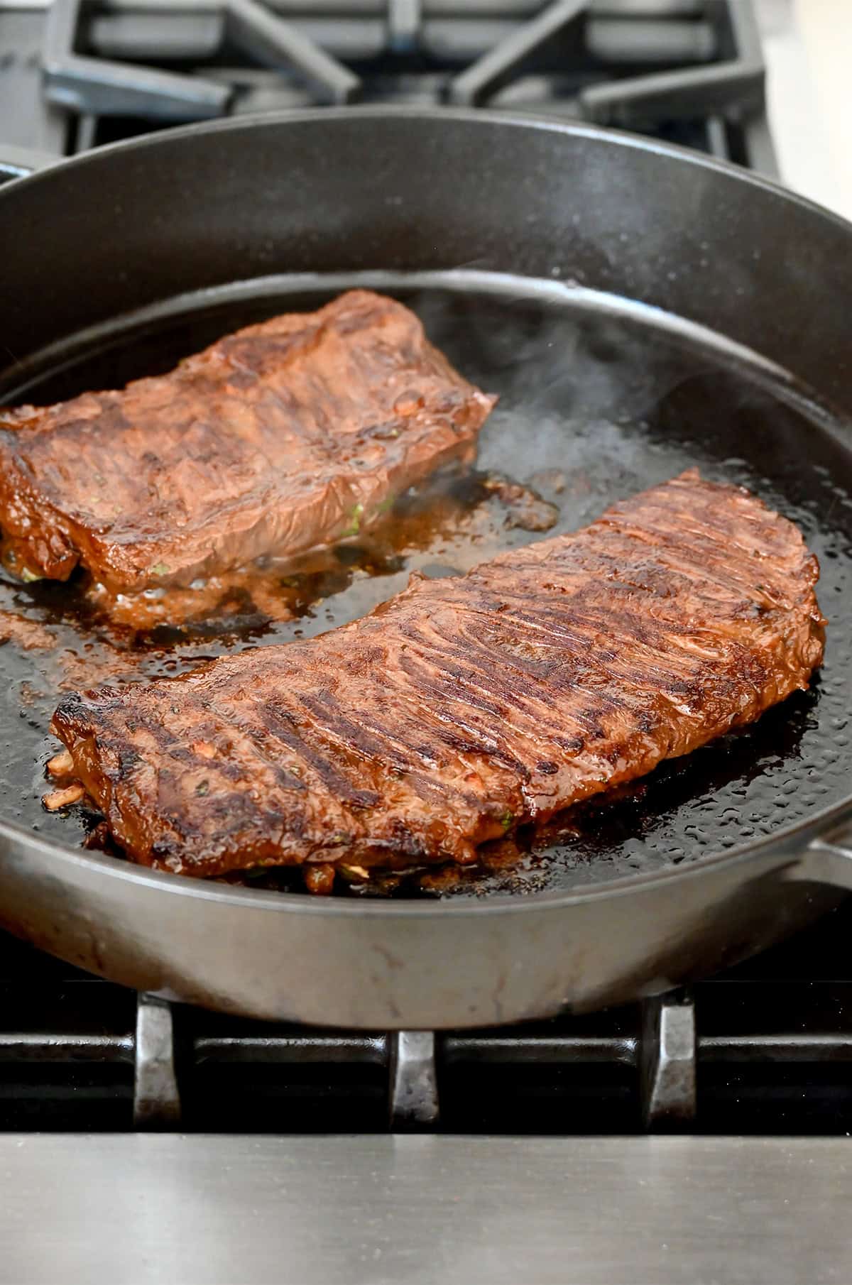Seared carne asada in a hot pan.