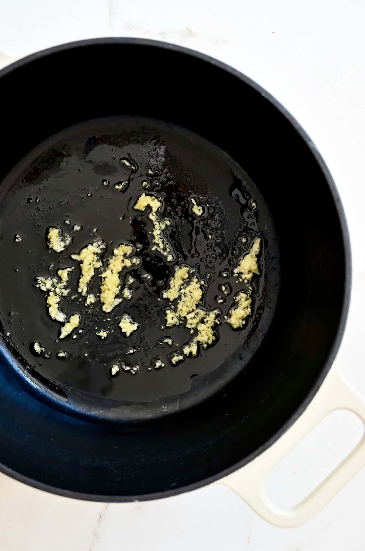 Saut&eacute;ed garlic in a large, heavy-bottomed stock pot with olive oil.